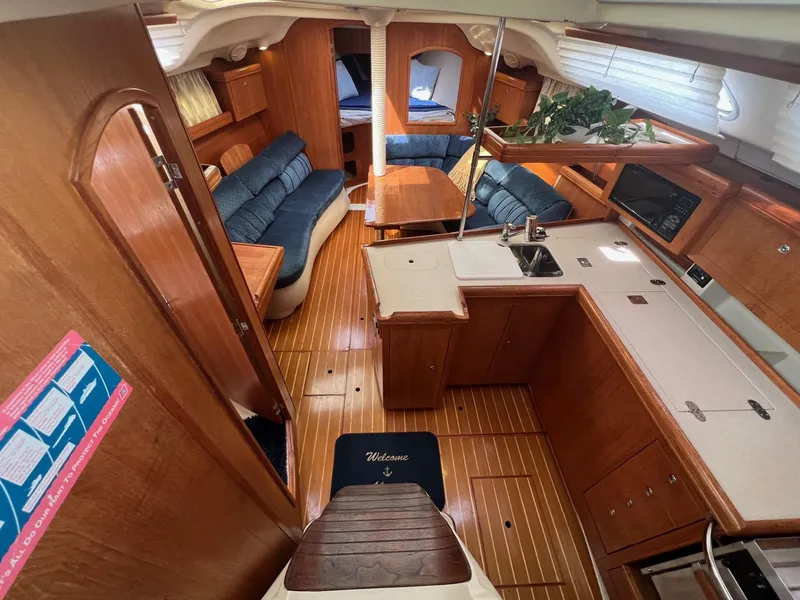 Slide: The Image of Interior of 2002 Hunter 386 sailboat with wood finish and blue seating. - 15