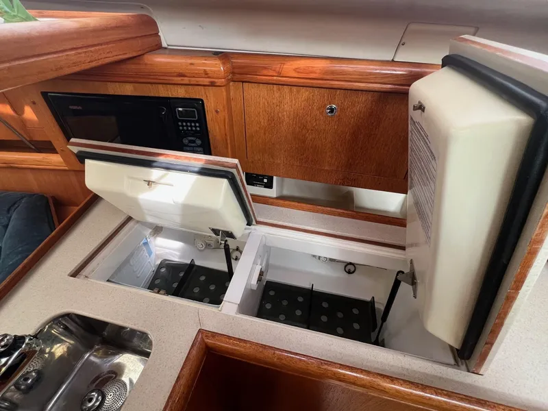 Slide: The Image of Interior of 2002 Hunter 386 yacht kitchen with open storage compartments. - 19