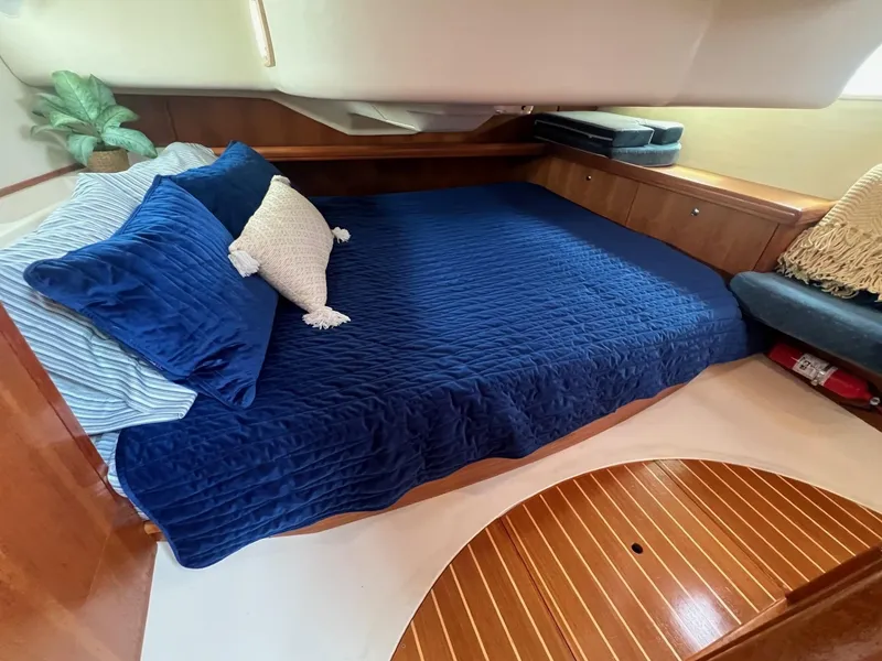 Slide: The Image of Cozy cabin interior of 2002 Hunter 386 sailboat with blue bedding and wooden accents. - 21