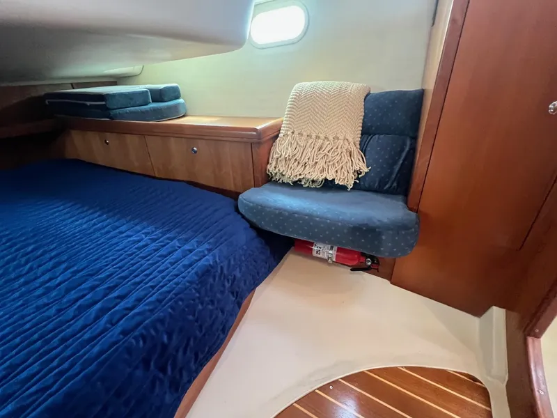 Slide: The Image of Cozy cabin interior of 2002 Hunter 386 sailboat with blue bedding and wooden accents. - 22