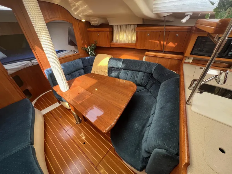 Slide: The Image of Interior of 2002 Hunter 386 sailboat with cozy seating and wooden finishes. - 27