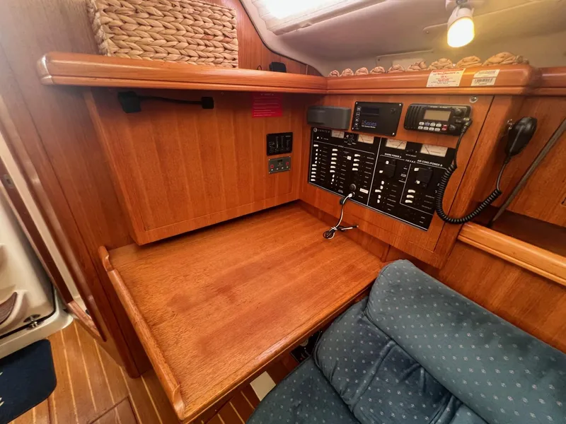 Slide: The Image of Navigation station in 2002 Hunter 386 sailboat with control panels and seating. - 29