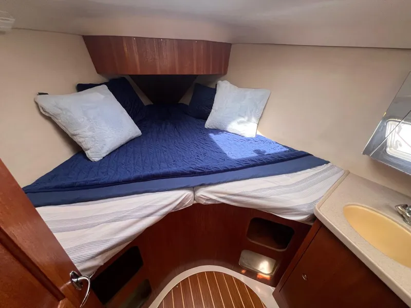 Slide: The Image of Cozy cabin interior of 2002 Hunter 386 sailboat with blue bedding and wooden accents. - 33