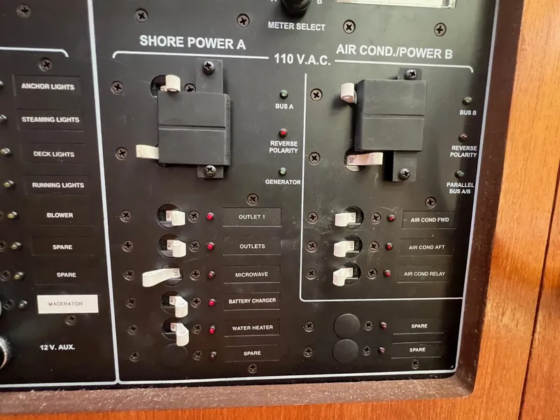 Slide: The Image of Electrical panel of a 2002 Hunter 386 boat, featuring shore power and air conditioning controls. - 36