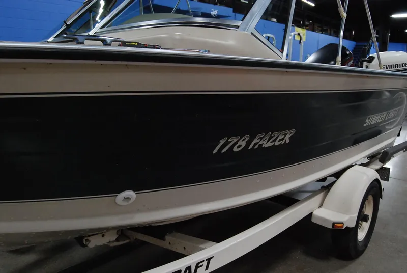 Slide: The Image of 1998 Smoker Craft 178 Fazer boat on trailer in indoor setting. - 11