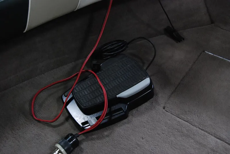 Slide: The Image of Foot pedal with red cable on carpeted floor of 1998 Smoker Craft 178 Fazer boat. - 27
