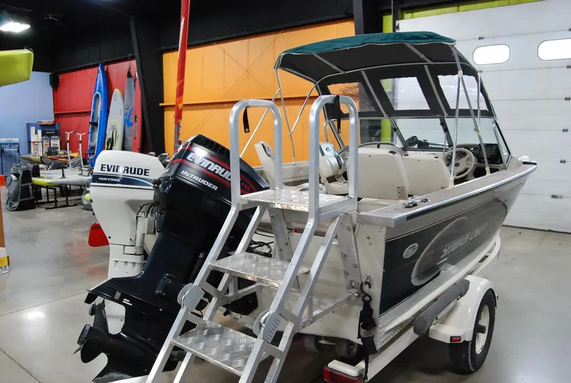 Slide: The Image of 1998 Smoker Craft 178 Fazer boat with outboard motors in a showroom. - 6