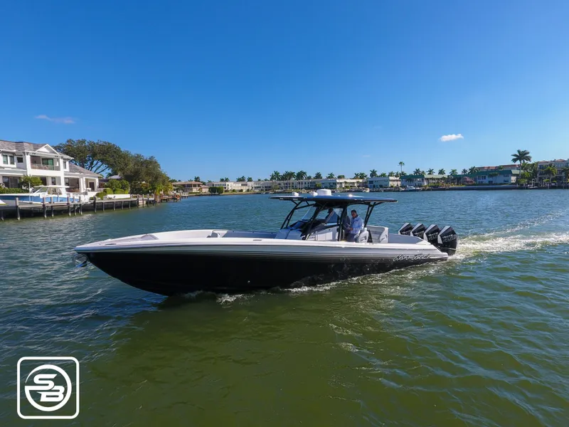 The Image of 2021 Nor-Tech 390 Sport boat cruising on a sunny day in a scenic waterfront area. - 1