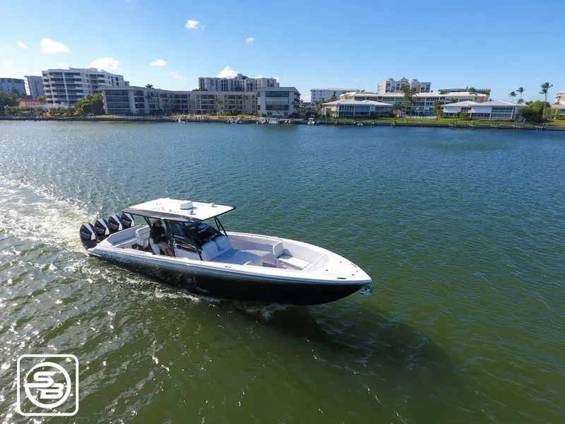 Slide: The Image of 2021 Nor-Tech 390 Sport boat cruising on a sunny day near waterfront buildings. - 10