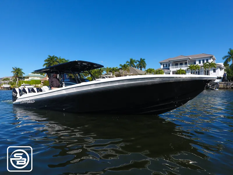 Slide: The Image of 2021 Nor-Tech 390 Sport boat on water, with luxury homes and palm trees in the background. - 12