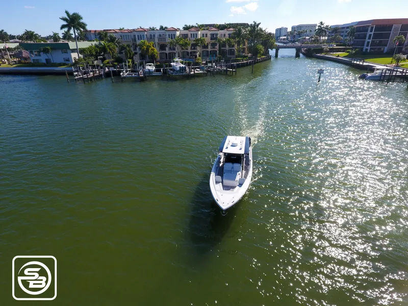 Slide: The Image of Aerial view of 2021 Nor-Tech 390 Sport boat cruising on a sunny canal. - 16