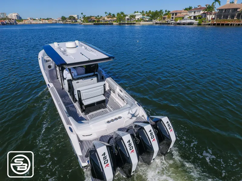 Slide: The Image of 2021 Nor-Tech 390 Sport boat cruising on a scenic waterway with quad engines. - 19