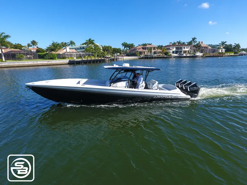Slide: The Image of 2021 Nor-Tech 390 Sport boat cruising on a sunny day near waterfront homes. - 4