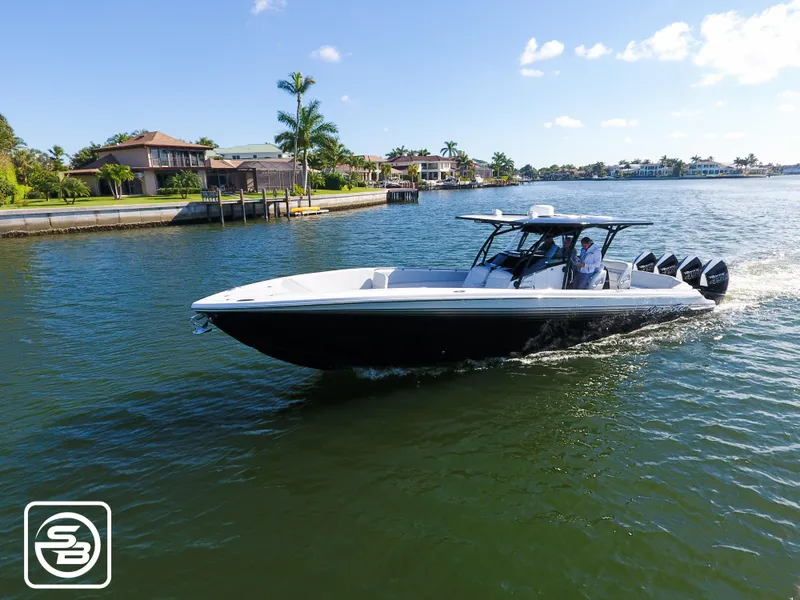 Slide: The Image of 2021 Nor-Tech 390 Sport boat cruising on a sunny waterfront. - 5
