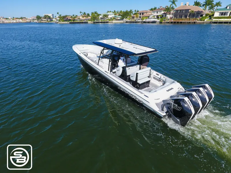 Slide: The Image of 2021 Nor-Tech 390 Sport boat cruising on a sunny day in a scenic waterway. - 6