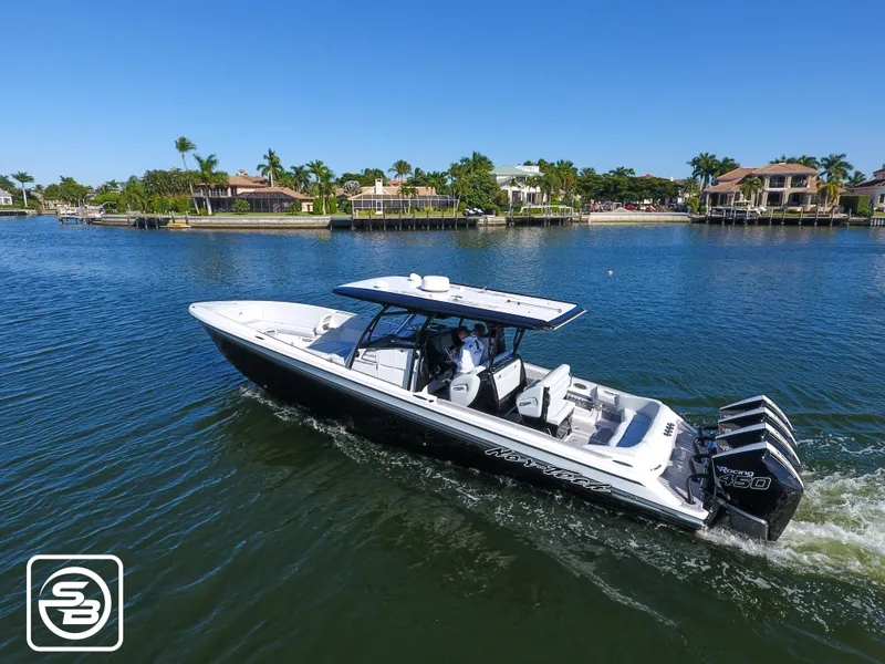 Slide: The Image of 2021 Nor-Tech 390 Sport boat cruising on a sunny day in a scenic waterfront area. - 8