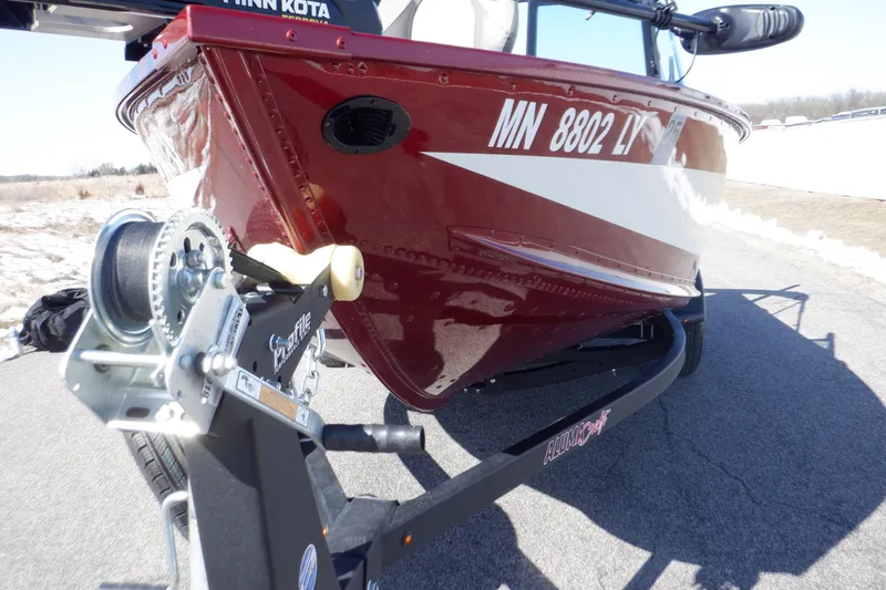 Slide: The Image of 2020 Alumacraft Competitor 165 Sport boat on trailer, red hull, close-up view. - 30