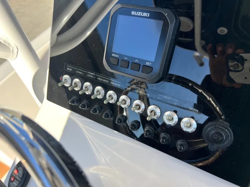 Slide: The Image of Control panel of 2024 Sea Pro 250 Bay boat with Suzuki display and switches. - 12
