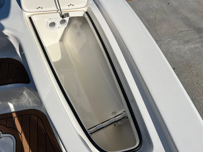 Slide: The Image of Open storage compartment on 2024 Sea Pro 250 Bay boat, featuring sleek design and wood accents. - 16