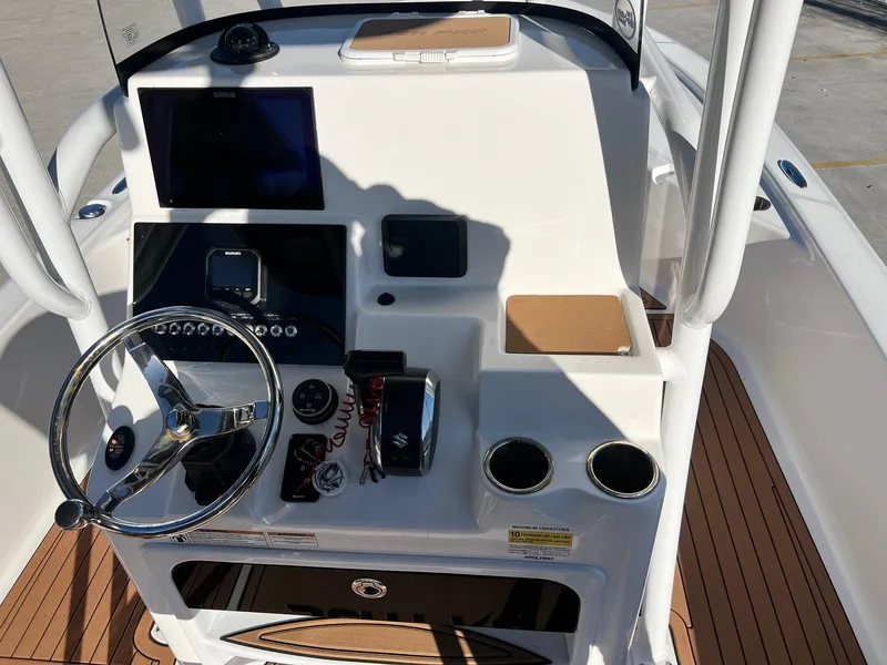 Slide: The Image of 2024 Sea Pro 250 Bay boat console with steering wheel, controls, and navigation display. - 21
