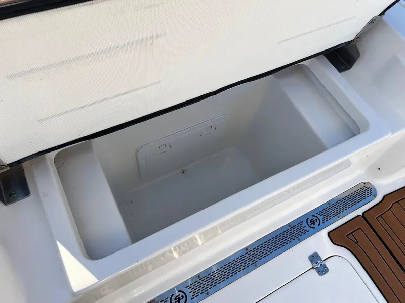 Slide: The Image of 2024 Sea Pro 250 Bay boat storage compartment with open lid, showcasing spacious interior. - 7