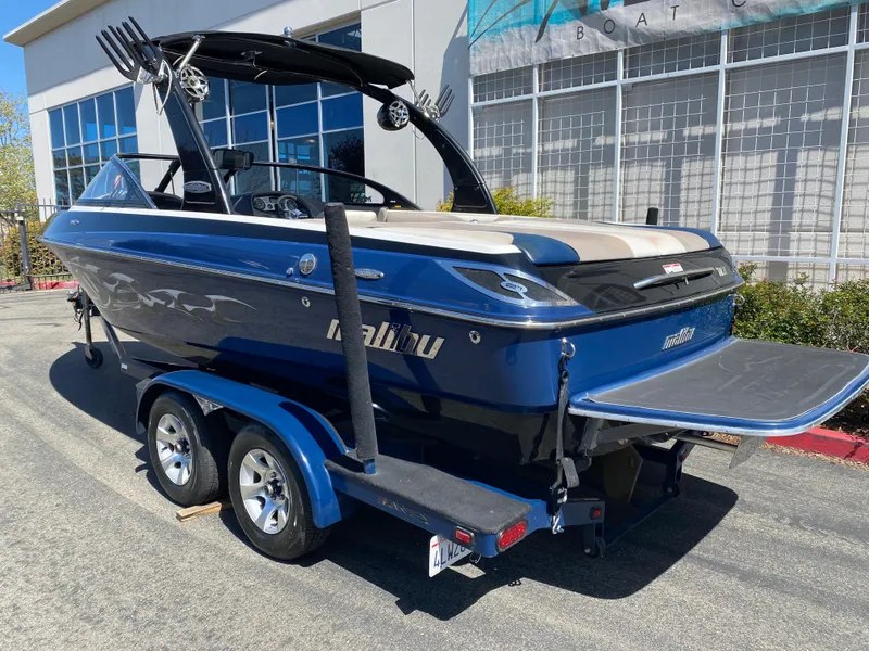 Slide: The Image of 2007 Malibu Wakesetter VLX boat on trailer, parked outside a building. - 3