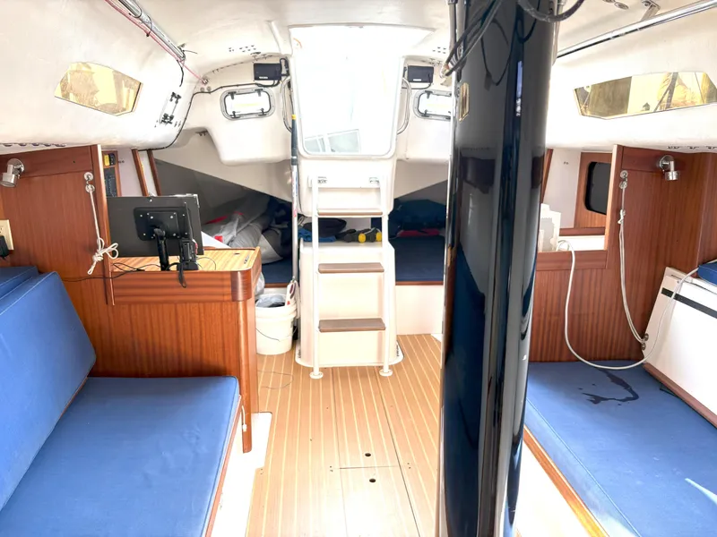 Slide: The Image of Interior of 2015 J Boats J 111 sailboat with blue seating and wooden accents. - 12