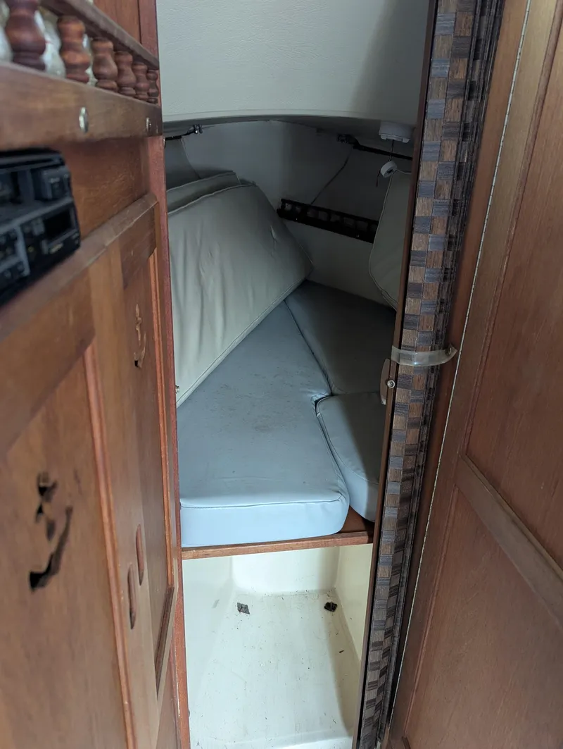 Slide: The Image of 1983 Catalina 27 cabin interior with cozy sleeping area and wooden cabinetry. - 10