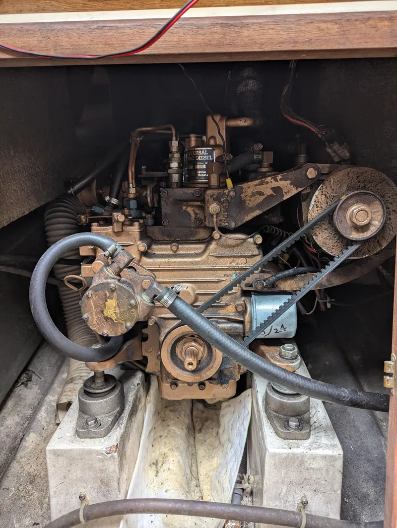 Slide: The Image of 1983 Catalina 27 engine compartment with visible belts and hoses. - 20