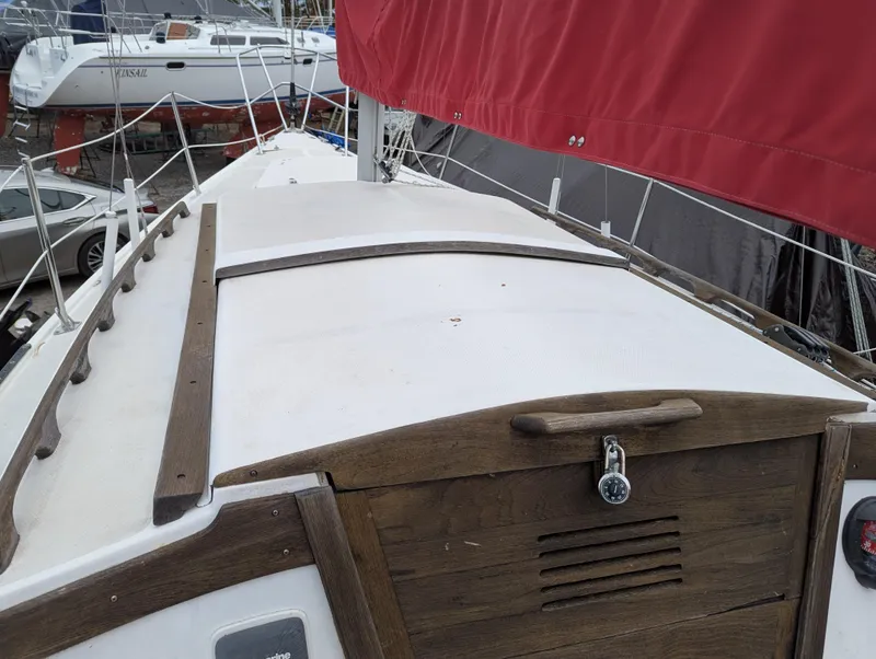 Slide: The Image of 1983 Catalina 27 sailboat deck with red sail and wooden hatch. - 3