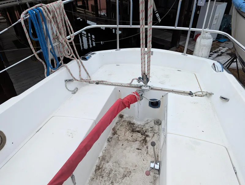 Slide: The Image of 1983 Catalina 27 sailboat cockpit with ropes and red cover, docked at marina. - 5