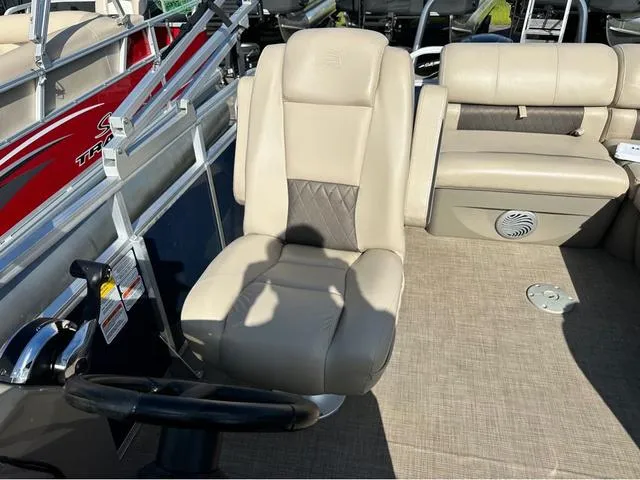Slide: The Image of 2021 Sun Tracker Party Barge 20 DLX interior with beige seating and steering wheel. - 9