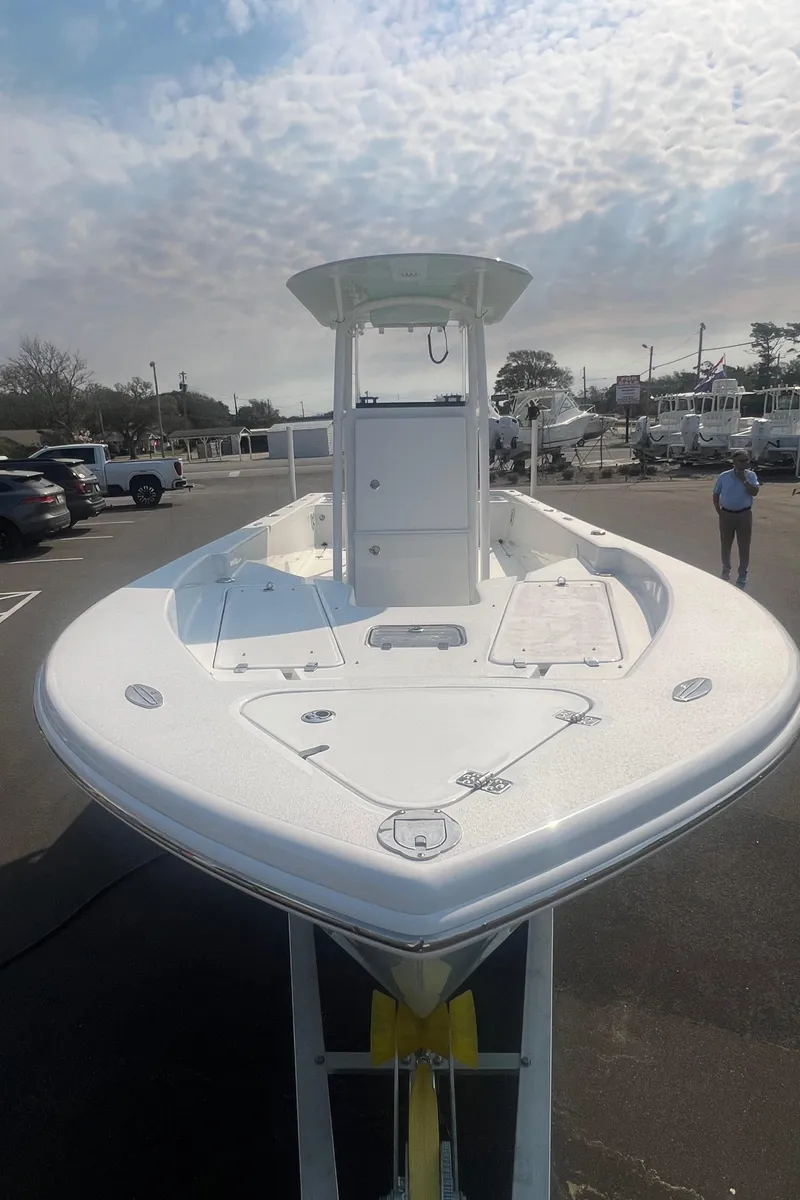 Slide: The Image of 2025 Pair Customs 24 Bay boat, sleek design, parked outdoors under a cloudy sky. - 14