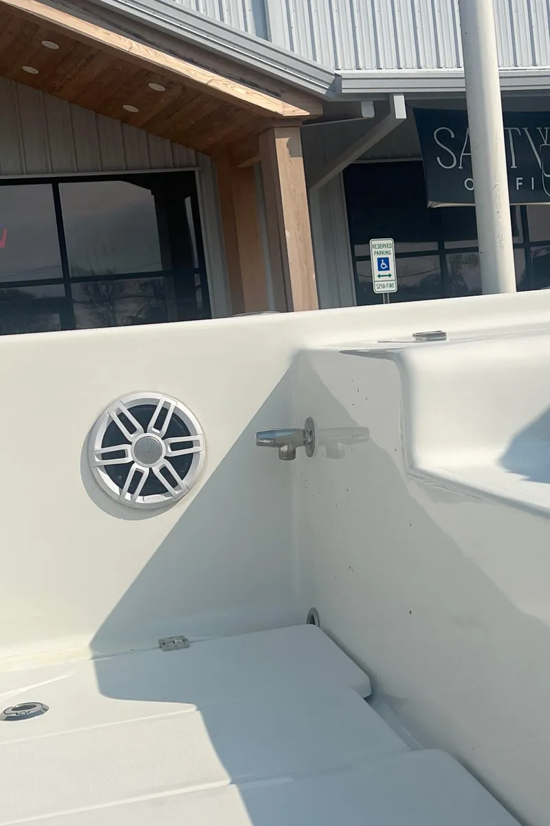 Slide: The Image of 2025 Pair Customs 24 Bay boat interior with speaker and dockside view. - 16