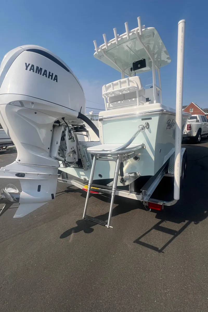 Slide: The Image of 2025 Pair Customs 24 Bay boat with Yamaha engine on trailer, sunny day. - 18