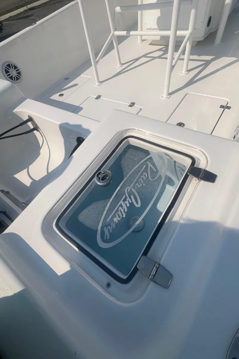 Slide: The Image of 2025 Pair Customs 24 Bay boat deck with storage compartment and seating. - 21