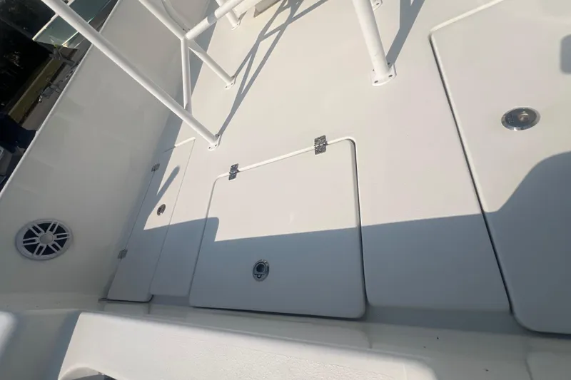 Slide: The Image of 2025 Pair Customs 24 Bay boat deck with storage compartments and speaker. - 24