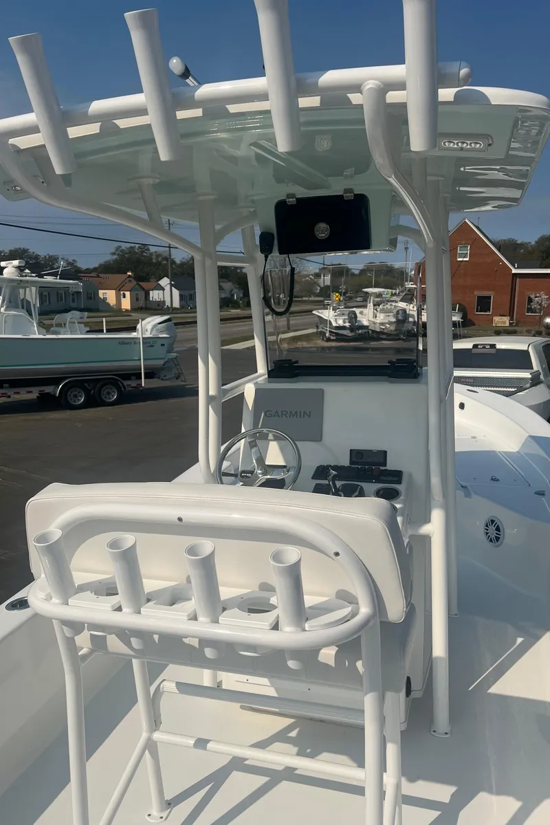 Slide: The Image of 2025 Pair Customs 24 Bay boat with T-top and rod holders, docked in a marina. - 25
