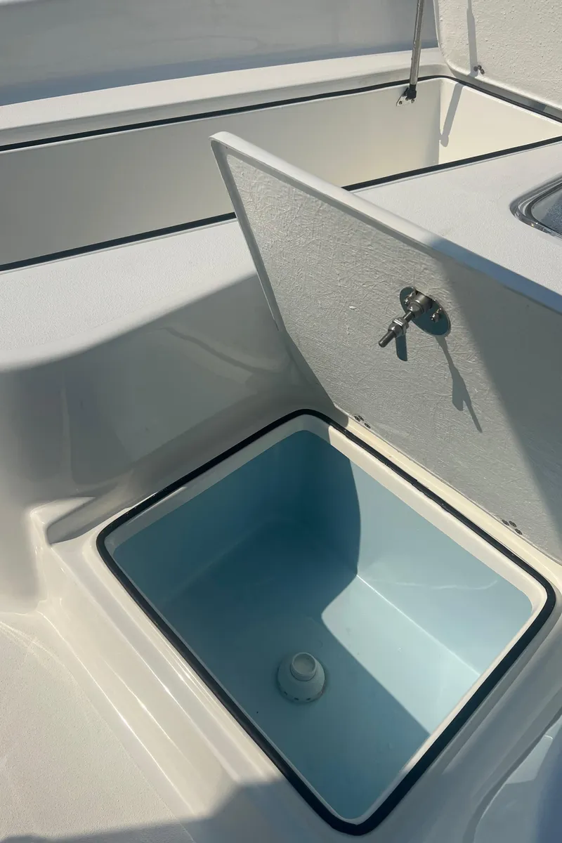 Slide: The Image of 2025 Pair Customs 24 Bay boat with open storage compartment. - 28