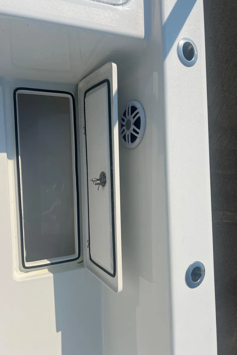 Slide: The Image of 2025 Pair Customs 24 Bay boat interior with storage compartment and speaker. - 35