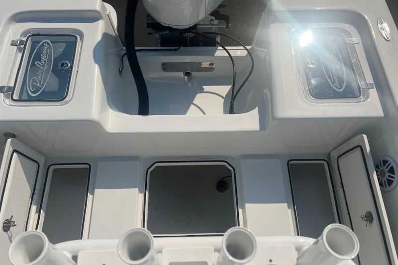 Slide: The Image of 2025 Pair Customs 24 Bay boat interior with storage compartments and rod holders. - 36