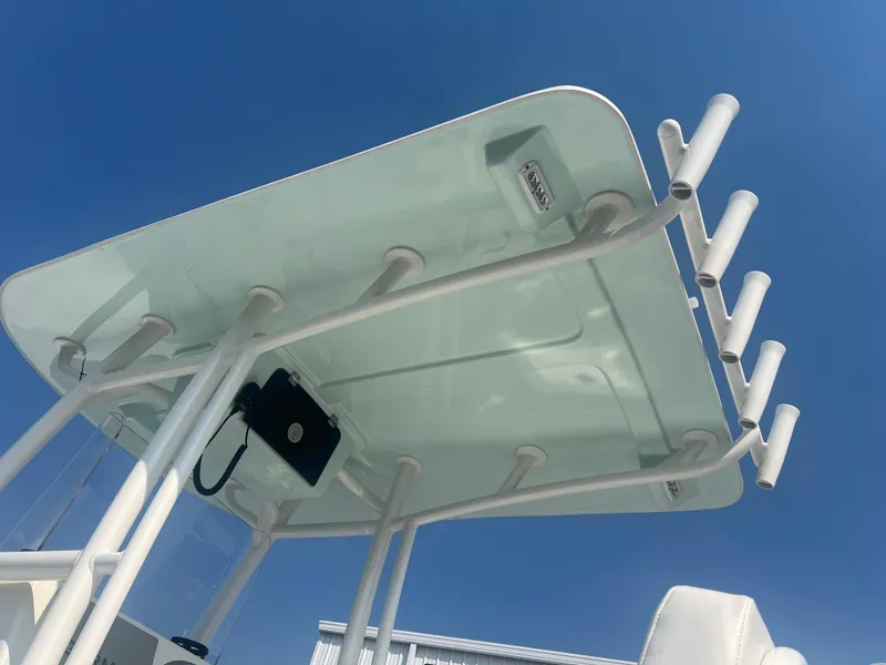 Slide: The Image of T-top of 2025 Pair Customs 24 Bay boat with rod holders against blue sky. - 6