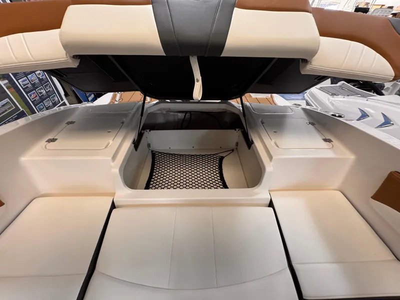 Slide: The Image of 2025 Chaparral 21 SSi OB boat interior with open storage compartment and cushioned seating. - 6