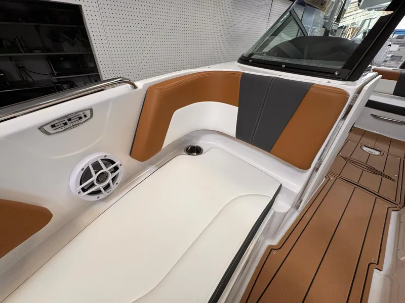 Slide: The Image of 2025 Chaparral 21 SSi OB boat interior with brown and white seating, speaker, and wood flooring. - 14