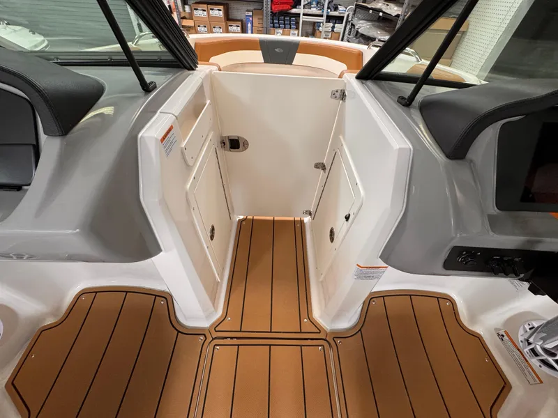 Slide: The Image of 2025 Chaparral 21 SSi OB boat interior with wood flooring and storage compartments. - 21
