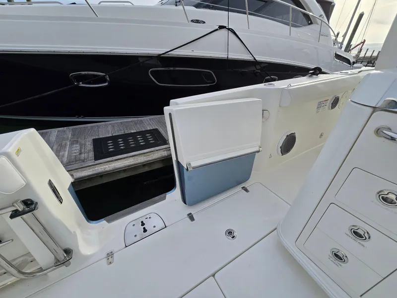 Slide: The Image of 2015 Boston Whaler 350 Outrage boat interior with open side door and dock view. - 16