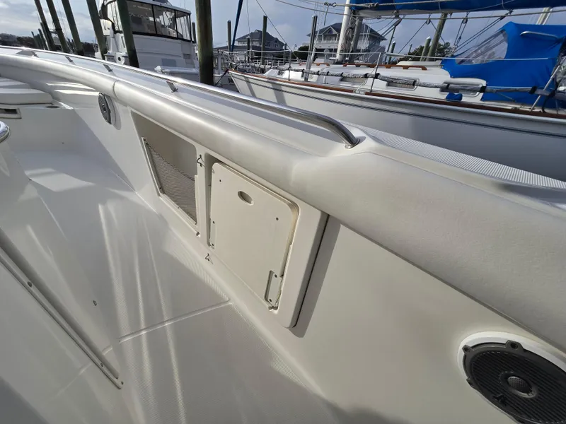 Slide: The Image of 2015 Boston Whaler 350 Outrage boat deck with storage compartments and railing. - 24