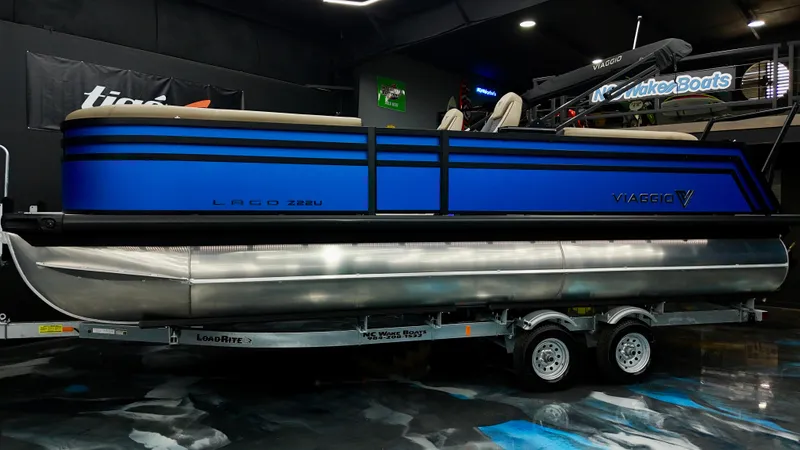 Slide: The Image of 2025 Viaggio Lago Z-U pontoon boat in showroom, blue exterior, on trailer. - 21