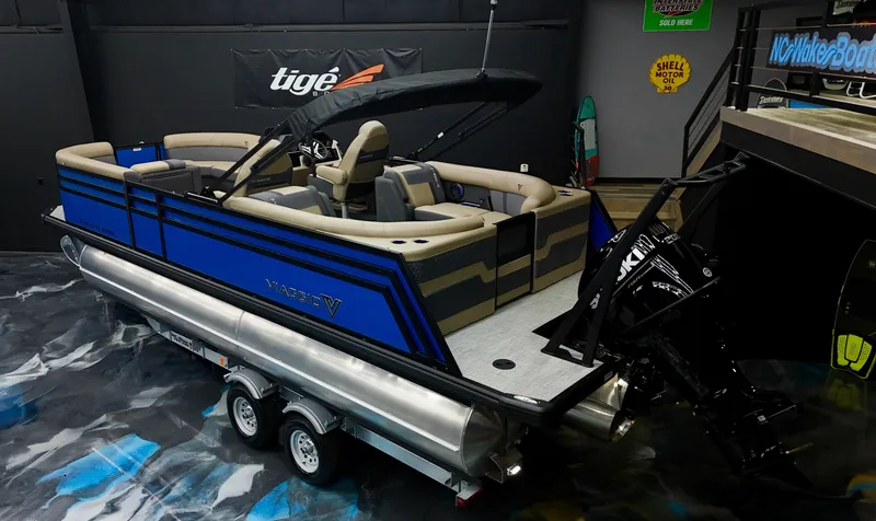 Slide: The Image of 2025 Viaggio Lago Z-U pontoon boat with blue accents in a showroom. - 23