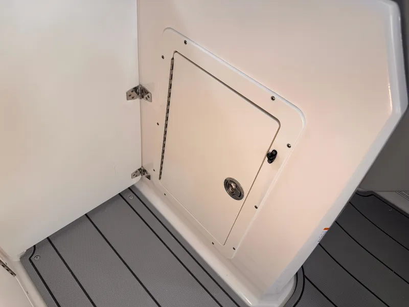 Slide: The Image of 2025 Chaparral 21 SSi OB boat interior storage compartment with sleek design and durable flooring. - 14